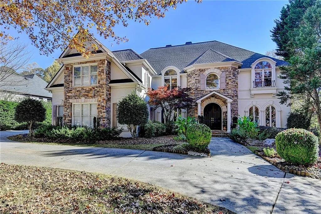 Stone and stucco front with a curved drive